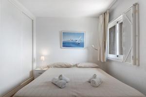 biała sypialnia z łóżkiem i ręcznikami w obiekcie Costa Isora 1 Frontline By Paramount Holidays w mieście Puerto de Santiago