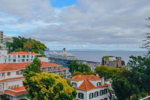 een stad met een cruiseschip in het water bij Casal da Penha Apartments in Funchal
