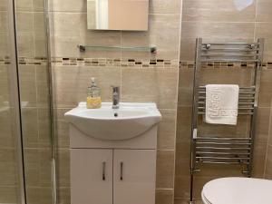 a bathroom with a white sink and a shower at The Sandrock in Clacton-on-Sea