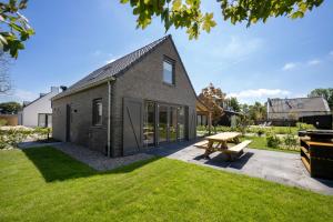 a brick house with a picnic table in the yard at Buiten aan zee by Droomvilla in Sint Maarten