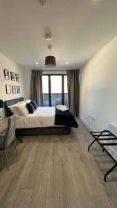 a large bedroom with a bed and a large window at Madison Court Apartments in Hemel Hempstead