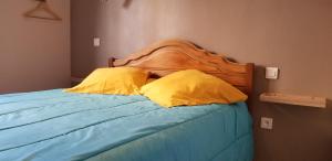 a bedroom with a bed with two yellow pillows at Maison Centre Ville Parking privé in Ax-les-Thermes