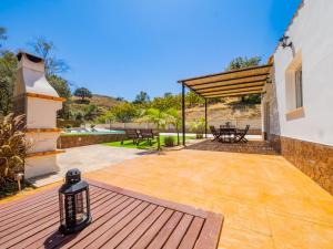a patio with a table and benches and a building at Cubo's Finca Armonia in Alhaurín el Grande