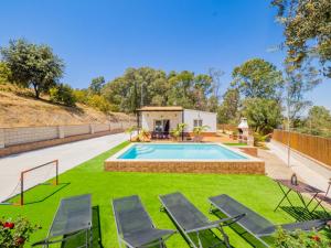 a backyard with a swimming pool and lawnitures at Cubo's Finca Armonia in Alhaurín el Grande
