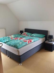 a bed with a blue comforter and two pillows at Breig,s Ferienwohnung in Broggingen