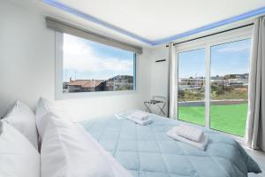 um quarto branco com uma cama e uma grande janela em GR House Eleftheria em Afantou