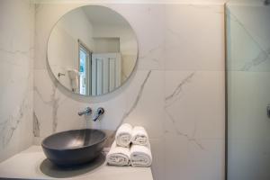 a bathroom with a sink and a mirror at Villa Theodora View Apartments Eleni in Agios Georgios Pagon +13 photos