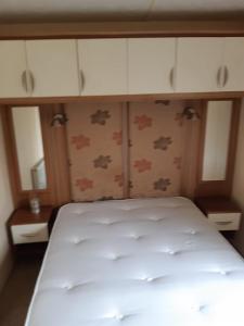 a bedroom with a white bed and cabinets at Holiday caravan Trough of Bowland in Settle