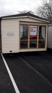 a trailer with a happy sell sign in a parking lot at Holiday caravan Trough of Bowland in Settle