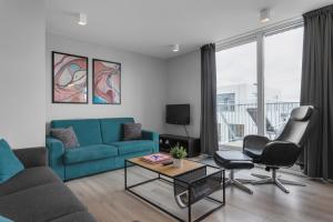 a living room with a blue couch and chairs at GreenKey Apartment V13 in Reykjavík