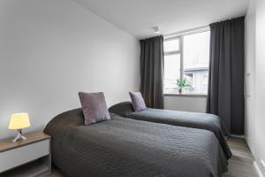a bedroom with two beds and a window at GreenKey Apartment V13 in Reykjavík
