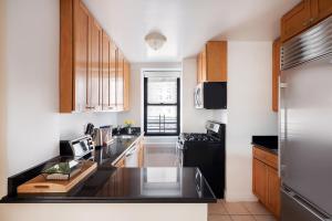 kuchnia z drewnianymi szafkami i czarnym blatem w obiekcie Luxury 3 Beds By Central Park w Nowym Jorku