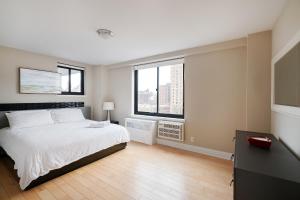 sypialnia z białym łóżkiem i 2 oknami w obiekcie Luxury 3 Beds By Central Park w Nowym Jorku