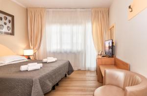 Hotel Stella D'Italia في فياريجيو: غرفه فندقيه بسرير وكرسي