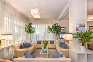 a large living room with couches and plants at Hotel Stella D'Italia in Viareggio