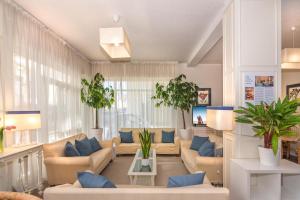 un ampio soggiorno con divani e piante di Hotel Stella D'Italia a Viareggio