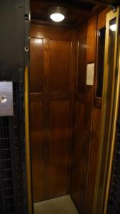 une pièce avec une porte en bois dans un train dans l'établissement Hotel Phenix Paris, à Paris