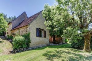 an old stone house with a tree in the yard at Les Perry, le calme et la nature à deux pas de Saint Léon in Peyzac-le-Moustier