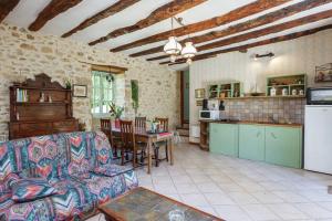 a living room with a couch and a table and a kitchen at Les Perry, le calme et la nature à deux pas de Saint Léon in Peyzac-le-Moustier