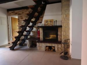 a living room with a stone fireplace and a staircase at holiday home, Rowy in Rowy