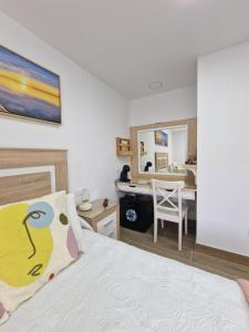 Alojamiento Agaete Pueblo Nº7 في أَغايتي: غرفة نوم مع سرير ومكتب مع كرسي
