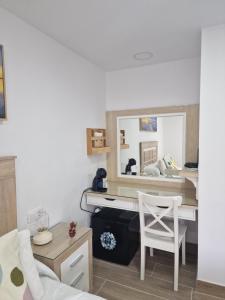 Zimmer mit einem Schreibtisch, einem Bett und einem Spiegel in der Unterkunft Alojamiento Agaete Pueblo Nº7 in Agaete