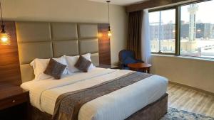 a hotel room with a large bed and a window at Rose Al Medina Hotel in Al Madinah