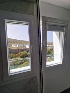 una puerta con 2 ventanas y vistas a un campo en Alojamiento Agaete Pueblo Nº7 en Agaete