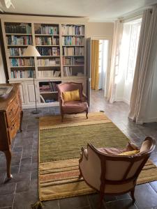 een woonkamer met een bank en een stoel bij Une Vie en Rose in Pressagny l'Orgueilleux
