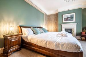 a bedroom with a large bed and a fireplace at Pass the Keys Williams Nest Period Dartmoor Apartment in stunning town setting in Newton Abbot