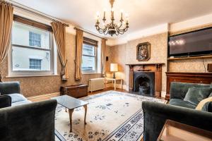 a living room with a fireplace and a chandelier at Pass the Keys Williams Nest Period Dartmoor Apartment in stunning town setting in Newton Abbot