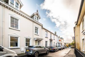 a street with cars parked in front of buildings at Pass the Keys Williams Nest Period Dartmoor Apartment in stunning town setting in Newton Abbot