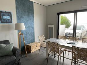 - un salon avec une table, des chaises et un canapé dans l'établissement Superbe maison face mer à Pirou, à Pirou