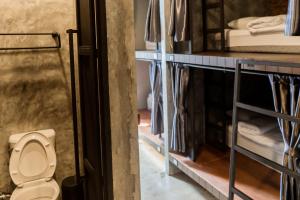 a bathroom with a toilet in a room with bunk beds at Premier Hostel Chiang Mai in Chiang Mai