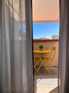 d'une table et d'une chaise sur un balcon avec une fenêtre. dans l'établissement La Mansarda del Sole, à Ortona