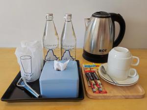 a table with two glass bottles and a coffee maker at Hotel Montha in Chiang Mai