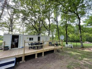 a mobile caravan with tables and chairs on a deck at Charmant Mobile Home en foret in Braize
