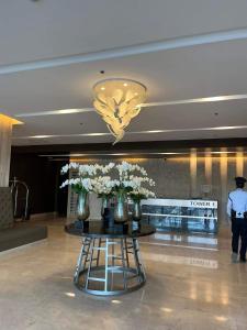 a lobby with a table with vases of flowers on it at Condo Shore 3 Residences MOA complex , near NAIA and Casinos in Manila