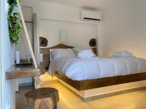 a bedroom with a swing bed with white sheets and towels at Èlia Luxury Rooms in Areopoli