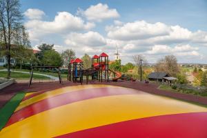 - une aire de jeux dans un parc avec un toboggan coloré dans l'établissement Kolping Holiday Resort, à Hévíz