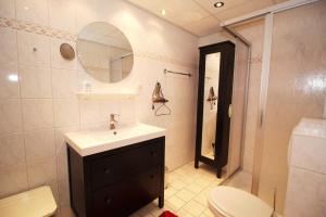 ein Badezimmer mit einem Waschbecken, einem WC und einem Spiegel in der Unterkunft Villa Seeblick - Apartment 408 in Sassnitz