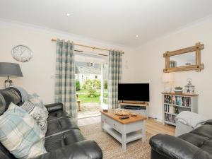 uma sala de estar com um sofá e uma televisão em Woodmans Cottage em Falmouth