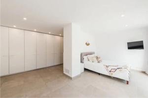 sala de estar con armarios blancos y sofá blanco en Villa Daniel, en Sant Jordi