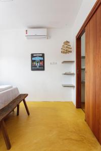 a bedroom with a bed and a white wall at Casa Sibite - Ilha do Ferro in Pão de Açúcar