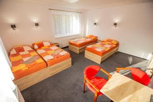 a room with three beds and a table and chairs at Hotel Rabbit in Trhový Štěpánov