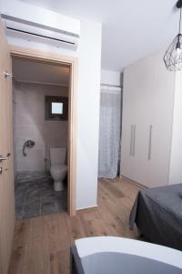 a bathroom with a tub and a toilet in a room at Lux Aprt in a Graphical Village in Kerásia