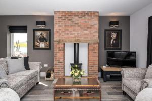 a living room with two couches and a brick fireplace at 4 Bedroom Barn conversion in Beamish County Durham in Durham
