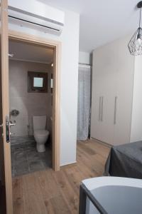 a bathroom with a toilet in a room at Lux Aprt in a Graphical Village in Kerásia
