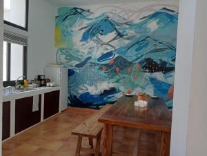 a kitchen with a table and a painting on the wall at Casa Mocan in Arrecife