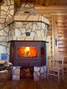 a stone fireplace in a log cabin with a bench at LogCabin Žabljak in Žabljak
